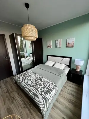 a bedroom with a bed with a black and white comforter at Black Sea Breeze Apartment No 3 in Byala