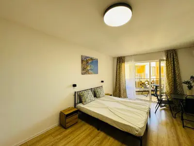a bedroom with a bed and a table at ROYAL PALM 84 Studio Sveti Vlas in Sveti Vlas