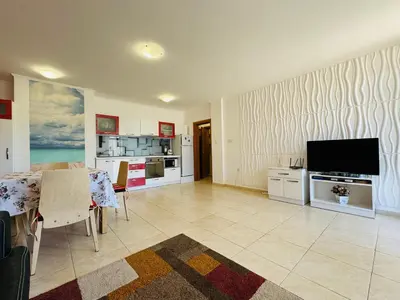 a large living room with a television and a kitchen at VODENICATA 3 Apartament Sveti Vlas in Sveti Vlas