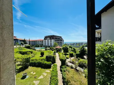 a view of a garden with a building in the background at VODENICATA 3 Apartament Sveti Vlas in Sveti Vlas