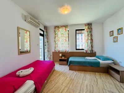a bedroom with two beds and two windows at VODENICATA 7 Apartment Sveti Vlas in Sveti Vlas