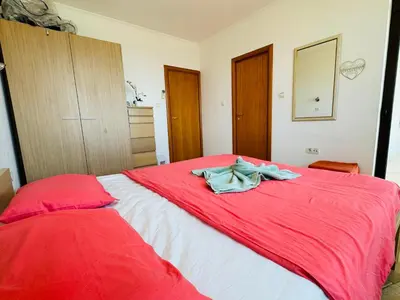 a bedroom with a red bed with a red blanket at VODENICATA 7 Apartment Sveti Vlas in Sveti Vlas