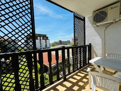 a balcony with a table and a view of a building at VODENICATA 4-10 Apartment Sveti Vlas in Sveti Vlas