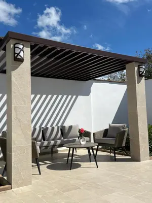 a pergola with two chairs and a table on a patio at Courtyard Villa, Aleksandrovo in Aleksandrovo