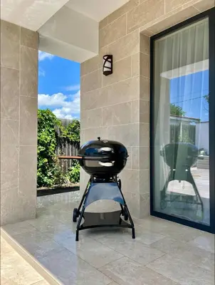 a barbecue grill sitting on a floor next to a window at Courtyard Villa, Aleksandrovo in Aleksandrovo