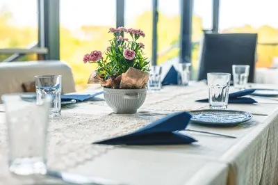 a table with a vase with purple flowers on it at Хотел и Вили Марая in Tsarevo
