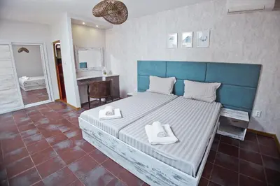 a bedroom with a large bed with two towels on it at Хотел и Вили Марая in Tsarevo