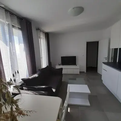 a living room with a couch and a tv at DELUXE Beach Apartment in Sveti Vlas in Sveti Vlas