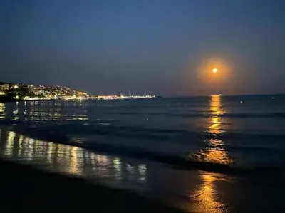 a view of the ocean at night with a full moon at DELUXE Beach Apartment in Sveti Vlas in Sveti Vlas