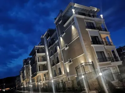 a tall white building with lights on it at DELUXE Beach Apartment in Sveti Vlas in Sveti Vlas