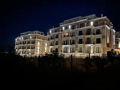 a large white building at night with lights at DELUXE Beach Apartment in Sveti Vlas in Sveti Vlas