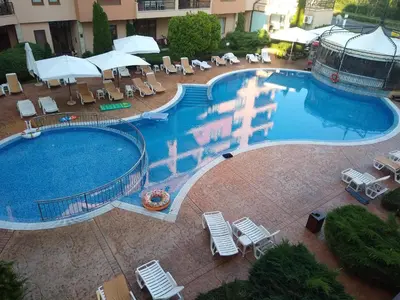 an overhead view of a large swimming pool with chairs and umbrellas at Tania's Home in Sunny Beach