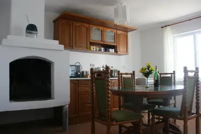 a kitchen with a fireplace and a table with chairs at Villa Sanaan in Bryastovets