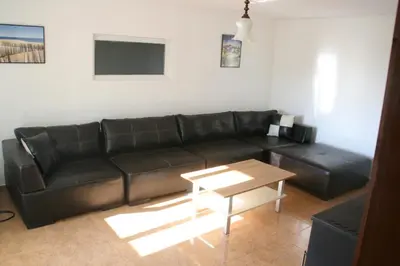 a black leather couch in a living room with a table at Villa Sanaan in Bryastovets