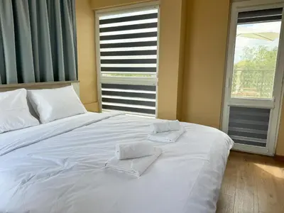 a bedroom with a white bed with two towels on it at Artistic Apartment for 4 Guests in Burgas in Burgas City
