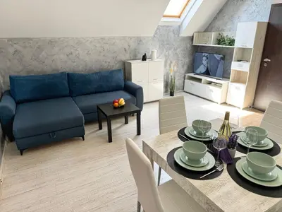 a living room with a blue couch and a table at Artistic Apartment for 4 Guests in Burgas in Burgas City