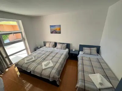 a bedroom with two beds and a window at Black Pearl Apartment in Sozopol