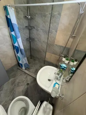 a bathroom with a sink and a toilet and a shower at Black Pearl Apartment in Sozopol