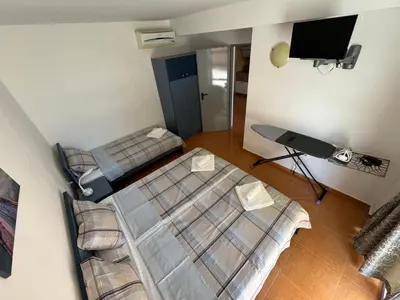 two beds in a room with a tv on the wall at Black Pearl Apartment in Sozopol