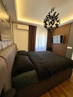 a bedroom with a large bed and a chandelier at Dolce Vita Premium Apartment Panorama Sea View in Sveti Vlas