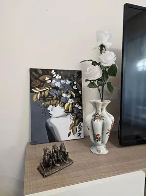 a table with a vase and a painting and a picture at Serenity in the heart of Varna with free parking in Varna City