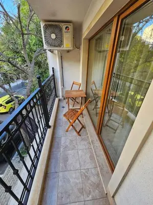 a balcony with a fan and a chair on a porch at Serenity in the heart of Varna with free parking in Varna City
