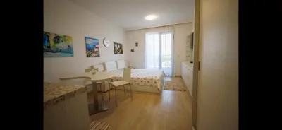 a small room with a bed and a table and a desk at Студио Сарафово in Burgas City