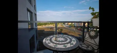 a balcony with a table and a view of a street at Студио Сарафово in Burgas City