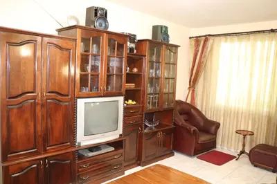 a living room with a large wooden entertainment center at Супер апартамент-център Варна in Varna City
