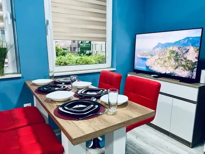 a dining room with a table and red chairs at NJ Deluxe rooms in Varna City