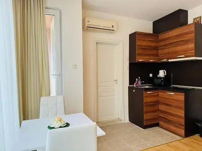 a kitchen with a white table and a white chair at ROMANCE MARIN 410 Studio Sunny Beach in Sunny Beach