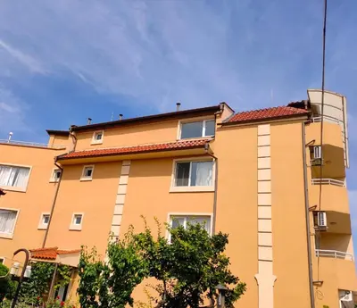 a yellow building with a red roof at Доли in Pomorie