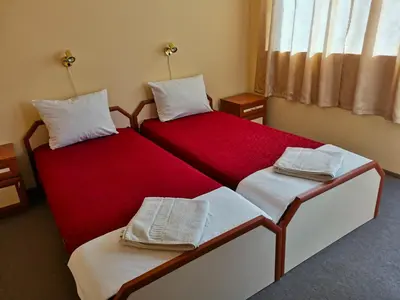 two beds in a room with red and white at Доли in Pomorie