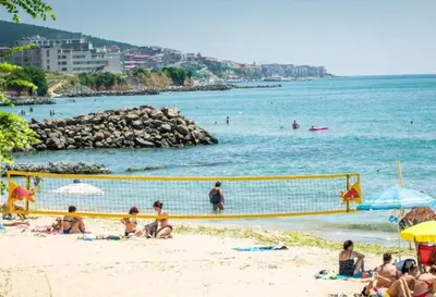 a group of people on a beach with a volleyball net at Premier Lux apartmán in Sveti Vlas