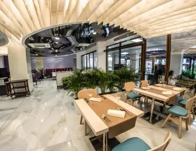 a dining room with tables and chairs in a building at Premier Lux apartmán in Sveti Vlas