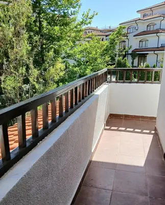 a balcony with a railing and trees and a building at Scenic, 2 Bedroom Apt with Views in Kableshkovo