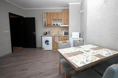a living room with a table and a kitchen at Sunset Apartment Atlantis Resort in Burgas City