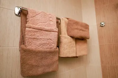 three towels are hanging on a towel rack in a bathroom at Sunset Apartment Atlantis Resort in Burgas City