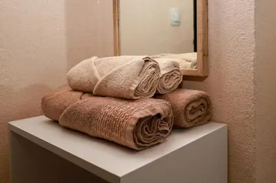 a pile of towels sitting on a shelf in a bathroom at Sunset Apartment Atlantis Resort in Burgas City