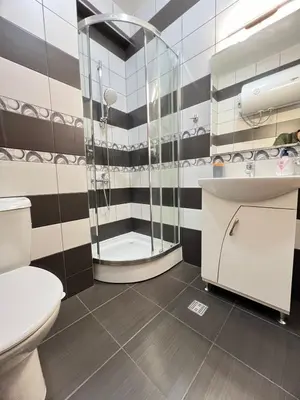 a bathroom with a shower and a toilet and a sink at Lazur Apartment AQUA in Burgas City