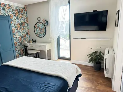 a bedroom with a bed and a desk and a tv at Anabel Home in Burgas City