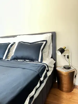 a bed with blue and white pillows and a lamp at Anabel Home in Burgas City