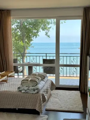 a bedroom with a balcony with a view of the ocean at Apartment Porto Chernomoretz in Chernomorets