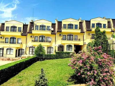 a large yellow building with a yard in front of it at Apartament Morela in Sunny Beach