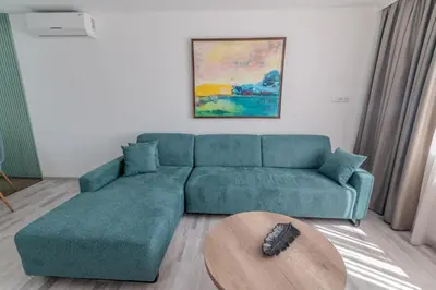 a living room with a green couch and a table at Sea Twins Luxury Aparthotel - 150 m from the beach in Sunny Beach