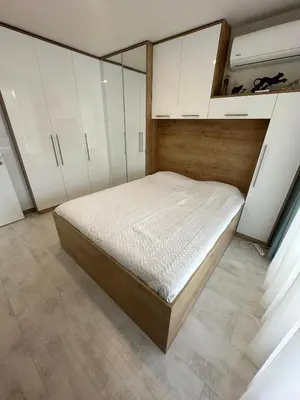 a bedroom with a bed and white cabinets at Pool apartment on the beach in Burgas City