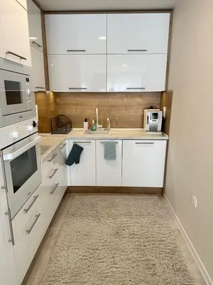 a white kitchen with a sink and a microwave at Pool apartment on the beach in Burgas City