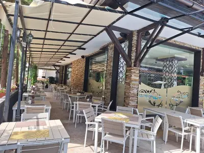 a restaurant with white tables and white chairs at Apartment102 Green Paradise Primorsko in Primorsko