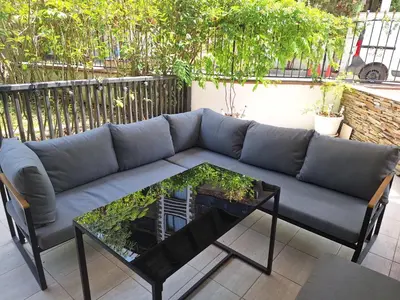 a blue couch and a coffee table on a patio at Apartment102 Green Paradise Primorsko in Primorsko