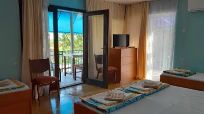 a room with two beds and a mirror and a balcony at Лятна вила Генчеви град Обзор in Obzor